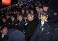 Taking a phone call from an athlete's family, President George W. Bush sits with America's Olympic athletes during the opening ceremonies for the 2002 Winter Olympic Games in Salt Lake City, Utah, Feb. 8. White House photo by Paul Morse.